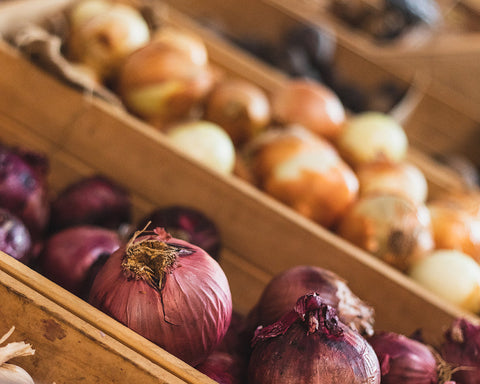 Onions displayed in wooden crates at a market